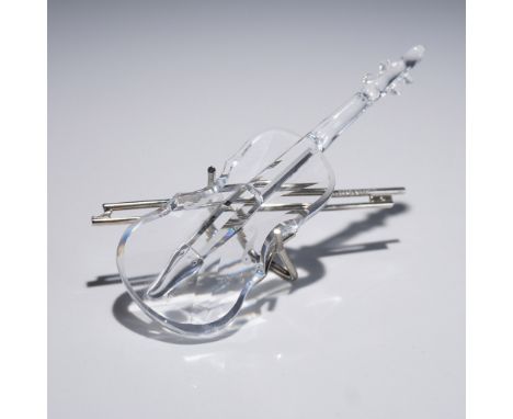 A finely crafted Swarovski crystal violin figurine, complete with a silver-tone metal bow and stand. This delicate piece capt