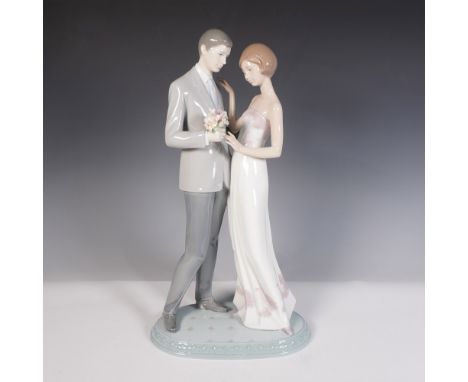 This elegant glazed piece captures a romantic moment between a newlywed couple. The groom, dressed in a sleek gray suit with 