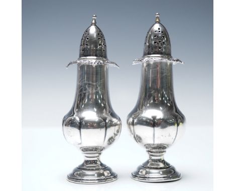 A pair of sterling silver salt and pepper shakers by Wallace Silversmiths in the Baroque Grande pattern. Featuring an elegant