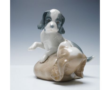 Charming porcelain figurine by Nao, a division of Lladro, titled Playful Pups. This delightful piece captures two young puppi