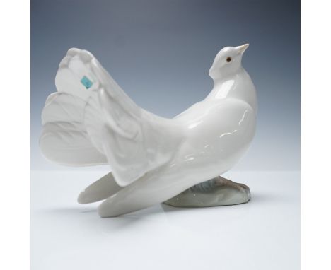 Gracefully sculpted in fine glazed porcelain, this elegant dove figurine by Lladro captures the gentle posture and flowing fo