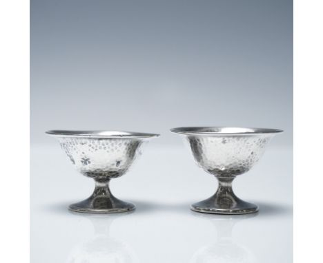 A pair of sterling silver egg cups with a hammered texture, marked "STERLING G H F" on the base. Each egg cup measures 1.25"H