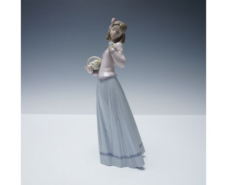 A charming porcelain figurine by Lladro titled Innocence in Bloom, model number 01007644. Issued in 1994 exclusively for Llad