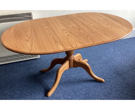 ERCOL: A small oval pedestal dining table. Est. £50 - £80.