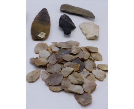 A COLLECTION OF EARLY KNAPPED FLINT AND STONE ARTIFACTS TO INCLUDE SPEAR HEAD, TWO SHAPED HAND AXE, CUTTING TOOLS ETC. 