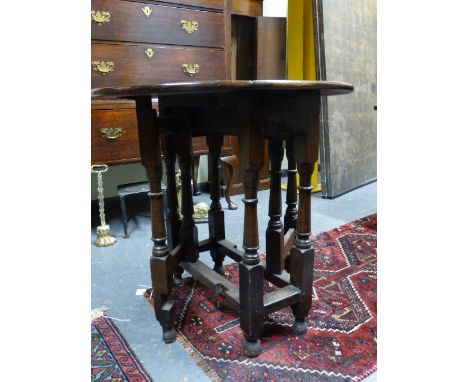 A SMALL ANTIQUE OAK GATE LEG TABLE WITH APRON DRAWER ON RING TURNED LEGS.