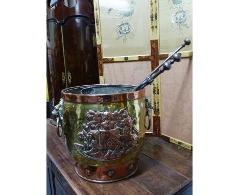AN ANTIQUE BRASS AND COPPER COAL BUCKET WITH ARMORIAL CRESTS AND LION  MASK HANDLES AND A SET OF THREE STEEL FIRE TOOLS. 