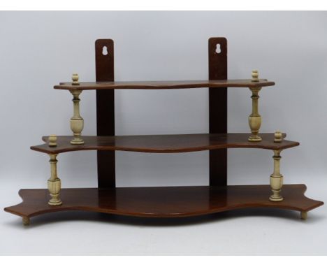 AN UNUSUAL VICTORIAN SMALL MAHOGANY AND IVORY THREE TIER HANGING SERPENTINE SHELF WITH TURNED IVORY SUPPORTS.