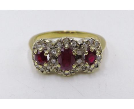 A 9CT. YELLOW GOLD RUBY AND DIAMOND TRIPLE CLUSTER RING. 