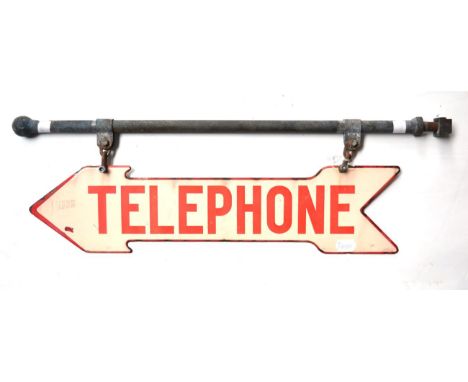 An Early 20th Century Double-Sided Enamel Telephone Sign, of arrow shaped form with red lettering on a cream ground, suspende