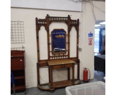 Substantial Edwardian walnut hall stand, with central shaped mirror surrounded by bronze hat hooks, having a single drawer an