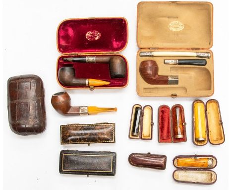 An assembled group of vintage smoking accessories, including three crocodile pipe cases (two with pipes included), an uncased