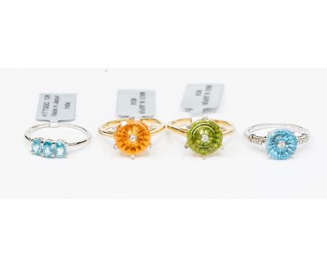 A collection of four 10ct yellow and white gold rings to include three Lehrer Torus rings set with synthetic Padparadscha sap