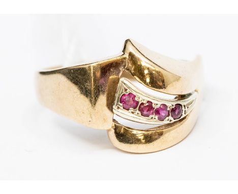 A 9ct gold and ruby ring, asymmetric mount, curved raised setting of  four round cut rubies, width approx. 10mm, size O, tota