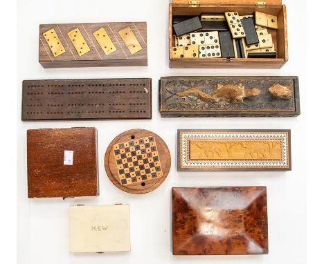 An assembled group of wooden gaming boxes, Edwardian and later, including a brass inlaid rosewood domino set, a mixed wood pa