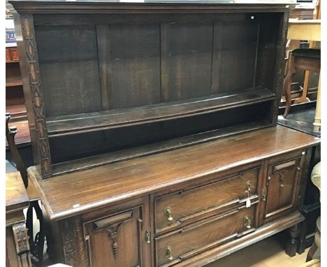 A 1920s oak sideboard, two doors and two drawers, rack above with adjustable shelf