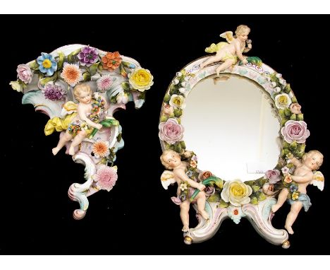 A Sitzendorf figural wall bracket, late 19th Century, of rocaille form, applied with trailing flowers and foliage and a putti