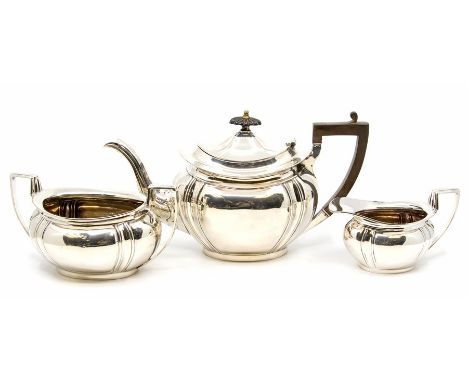 An Edwardian silver three piece tea service comprising teapot, sugar bowl and milk jug, oval bodies with lobed sections, the 