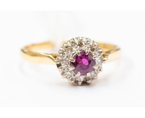 A ruby and diamond 18ct gold cluster ring, claw set with a round ruby, approx. 0.30ct, diamond set surround, size O, total gr