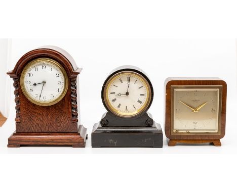 Two early 20th Century French mantel clocks, the first of barrel form on scroll base in ebonised wood with white enamel dial,