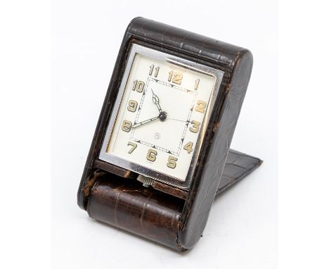 A Jaeger-LeCoultre crocodile cased travel alarm clock, with eight day movement in dark brown folding case monogrammed E.B., 1