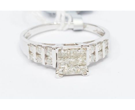 A diamond and 9ct white gold dress ring, the square setting set with nine princess cut diamonds, with round brilliant cuts se