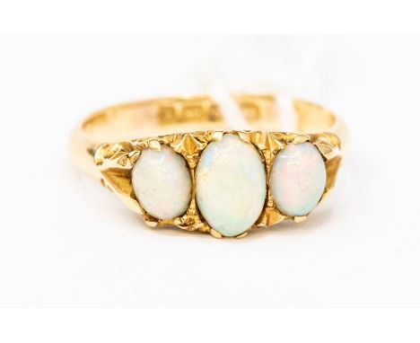 An early 20th Century opal ring, comprising three graduated oval opals set to fancy scrolled mount, size N, total gross weigh