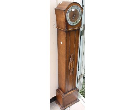 A 1930s oak eight day Grand Daughter clock, with three winder holes, Westminster chime, silvered chapter ring and Arabic nume