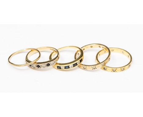 A collection of gold rings to include two 18ct gold stone set bands, one set with sapphire and diamond, size L, the other wit