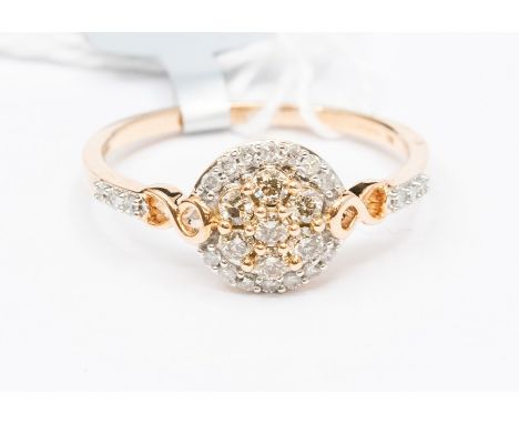 A diamond 10ct rose gold cluster ring, comprising a central dome set to the centre with a cluster of champagne diamonds, with