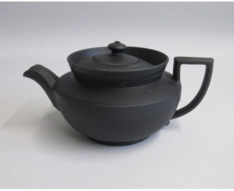 A Wedgwood Black Basalt Teapot and Cover, Engine turned with a turreted collar. Glazed insideDate: Late 19th early 20th centu