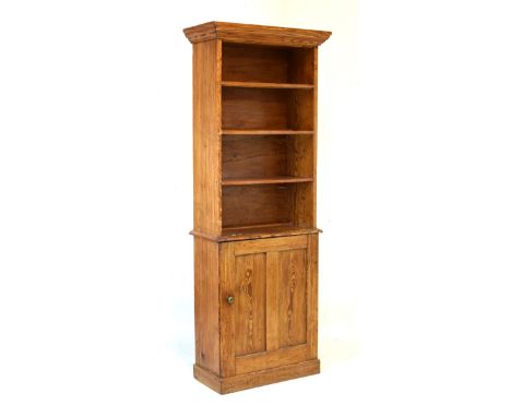 Late 19th/early 20th Century pitch pine bookcase on cabinet, the moulded cornice over four shelves, the lower stage with two 