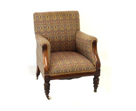 William IV/early Victorian walnut framed easy chair, the low overstuffed back between matching arms on curved front supports,