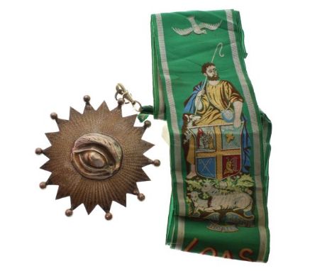 Early 20th Century white metal medallion, cast as an all-seeing eye within sunburst, the green sash with woven figure of Chri