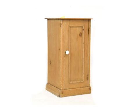 Pine bedside cabinet with single door enclosing shelf on plinth base   Condition: 