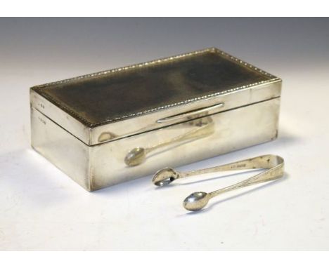 George V silver cigarette box of rectangular form, the hinged cover with engine turned decoration and raised border enclosing