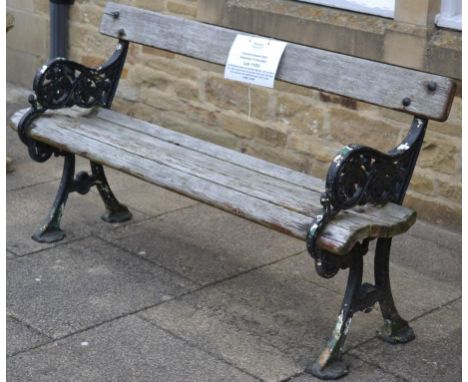 A Victorian Cast Iron Garden Bench, with scrolled arm rests supporting five wooden slats with standard end supports and flatt