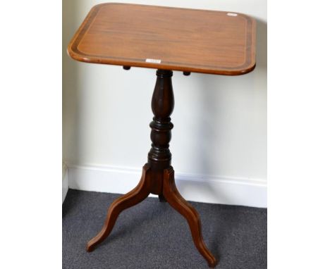 A George IV Mahogany and Rosewood Crossbanded Fliptop Tripod Table, of rounded rectangular form, raised on a vasi-form turned