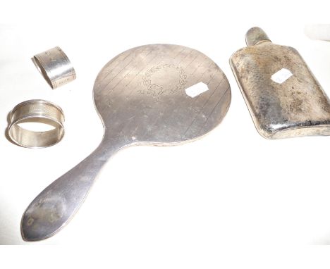 Silver backed hand mirror, two silver napkin rings and a silver plated hip flask