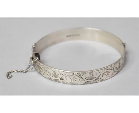 A Silver Bangle with Safety Chain, Birmingham 1963 Decorated with Engraved Scrolling 