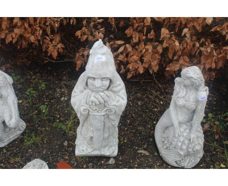 A cast concrete garden statue in the form of a large gate keeper holding a sword