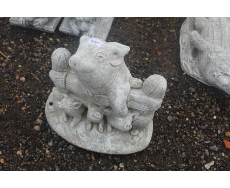 A cast concrete garden statue in the form of a mother pig and piglets over a gate 