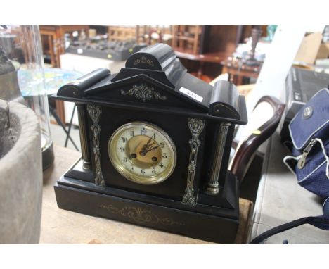 A late Victorian black slate two hole mantel clock