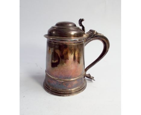 A late 17th century silver tankard with hinged domed lid, fancy thumb piece and scrolled handle, indistinct hallmarks clear m