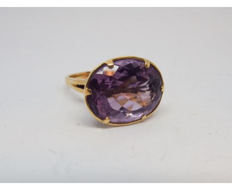 A large oval amethyst ladies dress ring set in unmarked yellow gold, amethyst diameter 2cms, ring size Q