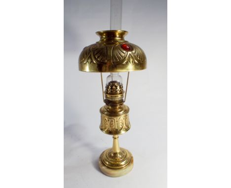 A brass and marbled based oil lamp with a be-jeweled brass shade