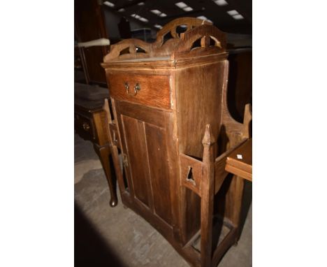 An early 20th Century oak "Arts & Crafts" hall cupboard stick standHaving a rectangular open work gallery above a single frie