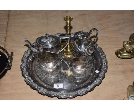 An EPNS tea service Six items to include a hot water jug, tea pot, sugar bowl and milk jug, brass candle stick and circular t