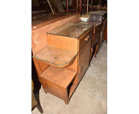 A 1930's Art Deco side cabinet Having a single frieze drawer above a cupboard door opposed by a rounded shelf and square pige