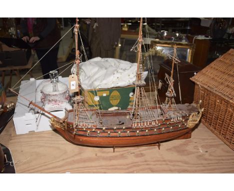 A model of a masted vessel With three masts and a green hull. 